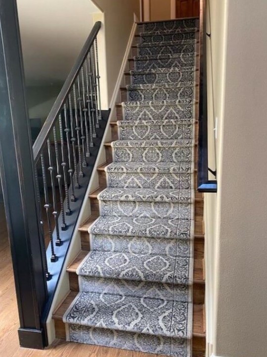 Beautiful blue patterned stair runner installation on wood floors