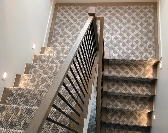 Gray and white patterned stair runner on a stair case